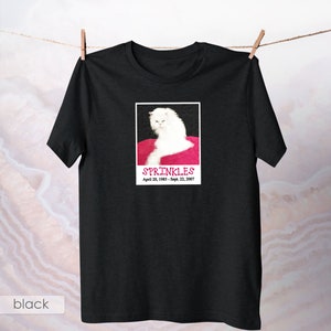 May include: Black t-shirt with a white cat photo and the text "SPRINKLES April 20, 1993 - Sept. 22, 2007"