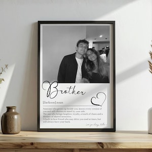 Peut inclure: Une impression encadrée en noir et blanc présentant une photographie de deux personnes au-dessus d'une définition de dictionnaire du mot Brother. Le texte inclut le nom Jackson, une définition de nom, une icône de cœur et la signature Love you always, Millie.
