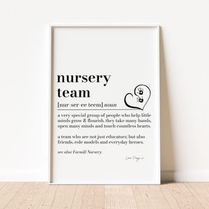 以下が含まれることがあります： nursery teamという用語を定義する黒いテキストが書かれた白い長方形のウォールアートプリント。デザインには、中に2つの小さな手形が入ったハート型のグラフィックが含まれており、テキストは次の通りです：a very special group of people who help little minds grow & flourish. they take many hands, open many minds and touch countless hearts. a team who are not just educators; but also friends, role models and everyday heroes. see also; Farmill Nursery. Love Freya x.