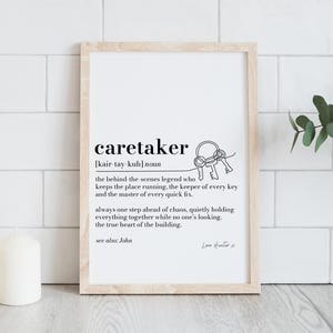 Könnte beinhalten: Gerahmter Druck mit dem Wort "caretaker" und seiner Definition, begleitet von einer Strichzeichnung von Schlüsseln. Der Druck befindet sich in einem hellen Holzrahmen und vor einem weißen Fliesen Hintergrund.