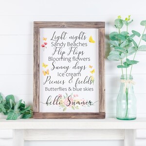 May include: A framed sign with a white background and brown wood frame. The sign features a summer-themed quote with text that reads: "Light nights, Sandy Beaches, Flip Flops, Blooming flowers, Sunny days, Ice cream, Picnics & fields, Butterflies & blue skies, hello Summer". The text is in black and the quote is decorated with watercolor butterflies and flowers.