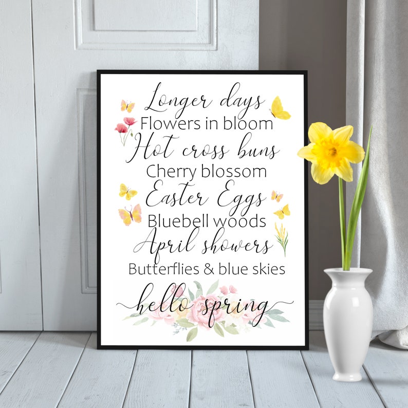 May include: A printable wall art design with a watercolor floral border and the text "Longer days, Flowers in bloom, Hot cross buns, Cherry blossom, Easter Eggs, Bluebell woods, April showers, Butterflies & blue skies, hello spring".