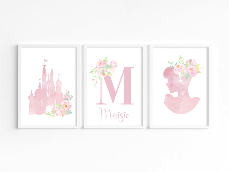 May include: Three watercolor prints featuring a pink castle, a pink letter M with floral accents, and a pink silhouette of a woman with a floral crown. The letter M is followed by the name "Maisie".
