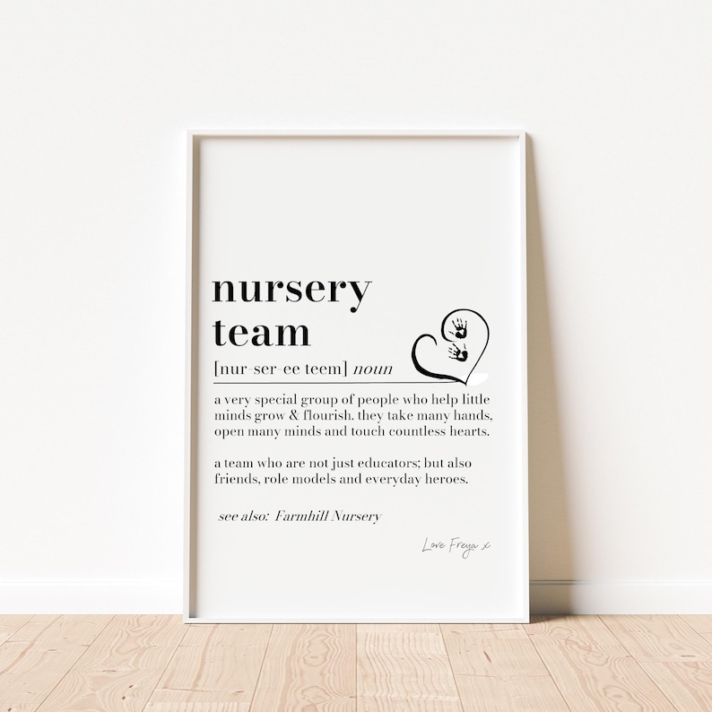 K&ouml;nnte beinhalten: Gerahmter Druck mit dem Text "nursery team" in Schwarz. Darunter steht die Definition des Begriffs, sowie ein Herz mit Handabdr&uuml;cken. Der Druck befindet sich in einem wei&szlig;en Rahmen, ideal f&uuml;r Kindertagesst&auml;tten.