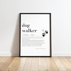 Könnte beinhalten: Ein gerahmter Kunstdruck mit einer wörterbuchartigen Definition des Begriffs dog walker. Der Text enthält den Namen Jasmine, eine Substantivklassifizierung, ein Herzsymbol und zwei schwarze Pfotenabdrücke. Der Druck ist schwarz gerahmt.