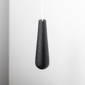 May include: Black wooden light pull with a teardrop shape.