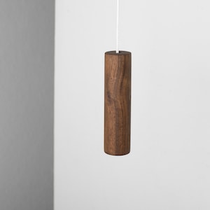 May include: A dark brown wooden pull chain for a light fixture.