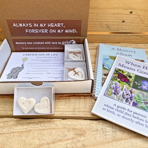 May include: A white box with the words "Always in my heart, Forever on my mind." printed on the top. The box contains a certificate of life, two white heart-shaped keepsakes, and a small book titled "When Hello Means Goodbye: A guide for parents whose child dies before birth, at birth, or shortly after birth."