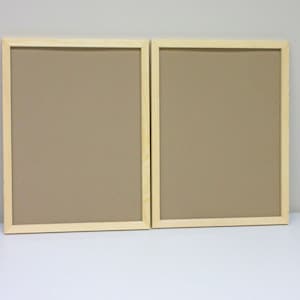 May include: Two natural wood picture frames with a light brown mat. The frames are empty and ready for photos or artwork.