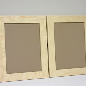 May include: Two natural wood picture frames with a light brown finish. The frames are empty and ready to be used to display photos or artwork.