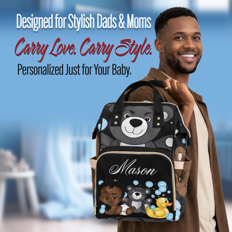 May include: A black and gray baby backpack with a bear design and the name "Mason" in white script. The backpack has a front pocket with illustrations of a baby, teddy bear, and rubber duck. The text "Designed for Stylish Dads & Moms" is at the top.