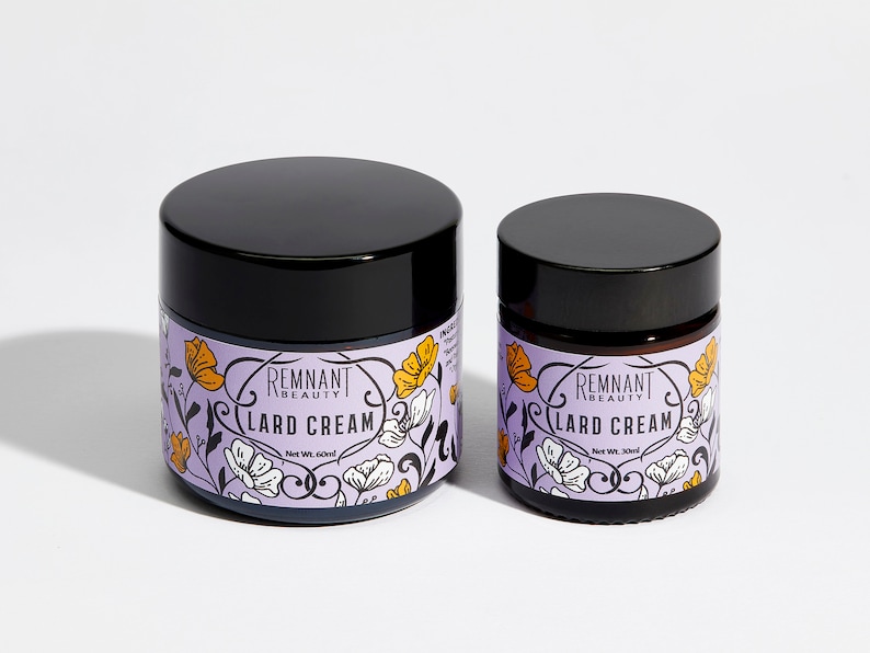 May include: Two jars of skin cream with floral designs. The larger jar is labeled "Remnant Beauty Lard Cream" with a net weight of 60 ml. The smaller jar is labeled "Remnant Beauty Lard Cream" with a net weight of 30 ml.