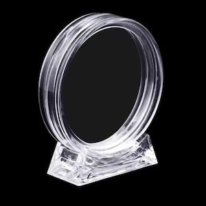 Op de afbeelding: Een ronde displayhouder van helder acryl met een dikke, transparante ringstructuur gemonteerd op een stevige, rechthoekige voet. Het ontwerp is volledig transparant, waardoor men door het midden van het ronde frame heen kan kijken.