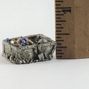 May include: A miniature pewter mine cart filled with colorful gems and beads. The cart is about 2 inches long and is a great addition to any miniature collection.