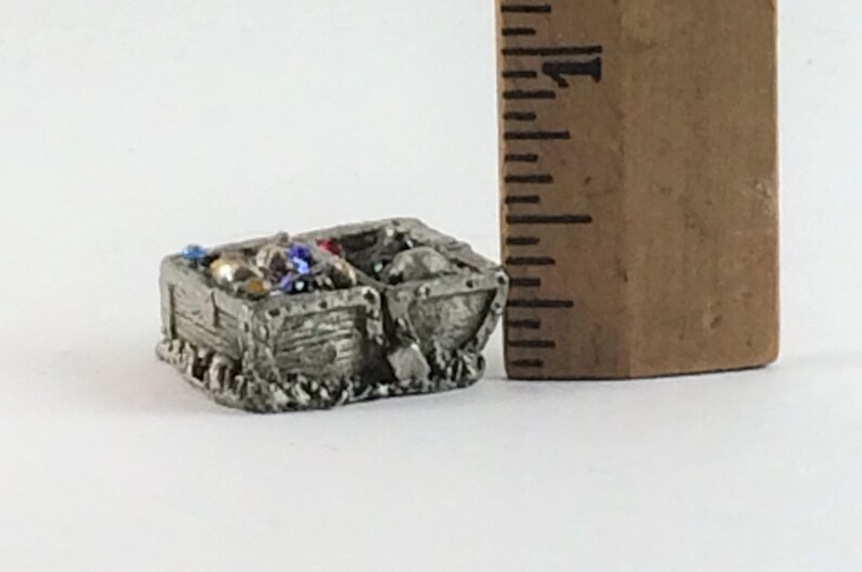 May include: A miniature pewter mine cart filled with colorful gems and beads. The cart is about 2 inches long and is a great addition to any miniature collection.