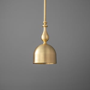 May include: A gold pendant light with a bell-shaped shade and a decorative finial.