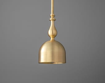 May include: A gold pendant light with a bell-shaped shade and a decorative finial.