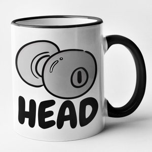 May include: White ceramic mug with a black rim and handle. The mug features a black and white illustration of two earbuds and the word "HEAD" in black text.