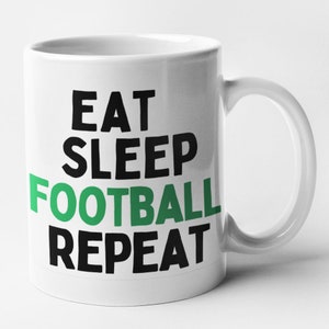 May include: White ceramic mug with black text that reads "Eat Sleep Football Repeat". The word "Football" is in green.