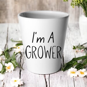 May include: White ceramic planter with black text that reads "I'm a Grower".