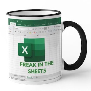 May include: White ceramic mug with a black handle and rim. The mug features a green and white Excel spreadsheet design with the text "FREAK IN THE SHEETS" in green. The Excel logo is also visible.