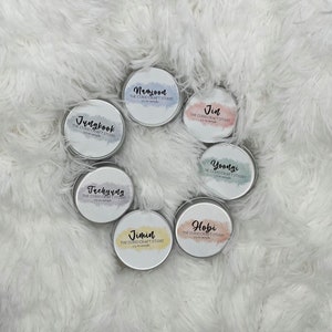 May include: Seven round metal tins with colorful watercolor designs and the names of the members of the K-pop group BTS: Jungkook, Namjoon, Jin, Taehyung, Yoongi, Jimin, and Hobi. Each tin has the text "The Curio Craft Studio" and "1/2 oz sample".