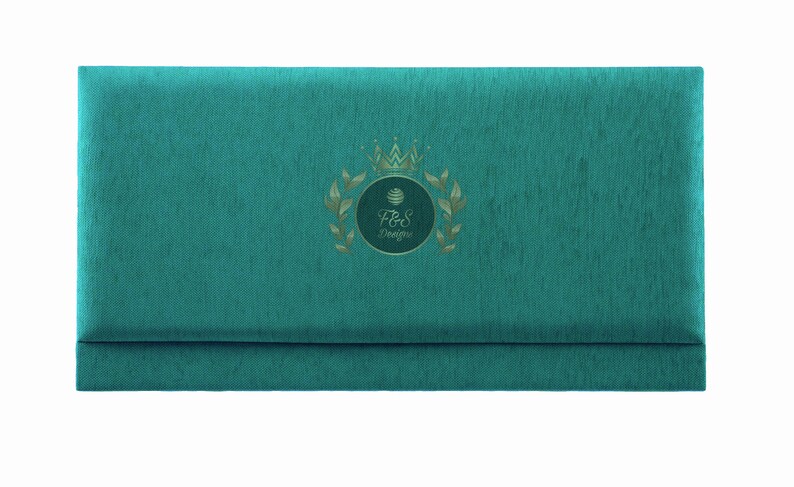 May include: Teal blue fabric envelope with a gold crown and laurel wreath design. The text "F&S Designs" is inside the wreath.