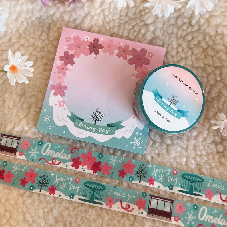 May include: Two rolls of washi tape with a spring theme. The tape features a light blue background with pink cherry blossoms, a carousel, and the text "Spring Day". One roll is labelled "Pink Little Clouds" and the other is labelled "Omelas".