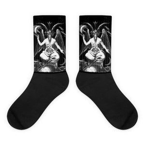 May include: A pair of black socks with a black and white illustration of Baphomet. The image depicts a goat-headed figure with a crescent moon and star. The design is printed on the upper part of the socks, with solid black on the foot and cuff.