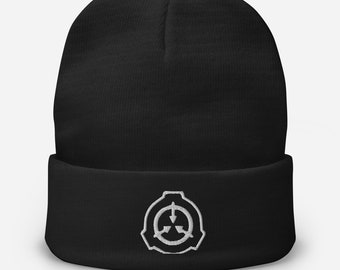 May include: Black beanie with a white embroidered logo of a circle with three arrows pointing inwards. The logo is commonly associated with the SCP Foundation.