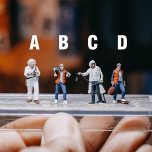 May include: Four miniature figures of a man wearing a white suit, a man wearing a red waistcoat, a man wearing a white coat, and a man wearing a blue waistcoat. The figures are standing on a clear plastic surface labelled with the letters A, B, C, and D.