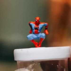 May include: A red and blue action figure of Spider-Man in a jumping pose. The figure is made of plastic and has a detailed design.