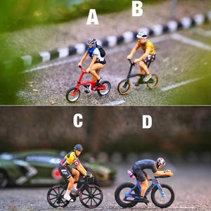 Könnte beinhalten: Miniaturfiguren von Radfahrern auf Fahrrädern. Das Bild zeigt vier Radfahrer auf verschiedenen Arten von Fahrrädern, darunter ein rotes BMX-Rad, ein grünes Fahrrad und zwei Rennräder. Die Radfahrer tragen Helme und Radbekleidung.