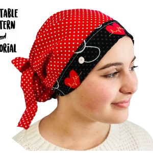 Pode incluir: Um gorro de trabalho vermelho e preto com bolinhas brancas e um coração com um design de linha de batimento cardíaco. O gorro tem uma gravata e um botão no lado.