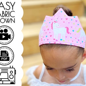 May include: A pink fabric crown with a unicorn and hearts print. The crown is worn by a child. The image includes the text "EASY FABRIC CROWN" and icons for video, PDF, and a sewing machine.