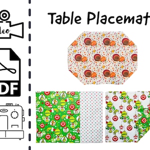 May include: A set of three table placemats featuring different holiday designs. The first placemat has a white background with a repeating pattern of turkeys, pumpkins, and leaves. The second placemat has a white background with a repeating pattern of green and red ornaments. The third placemat has a green background with a repeating pattern of green ornaments and a Grinch character.