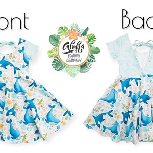 May include: A blue and white dress with a whale print. The dress has a tie at the back and short sleeves. The dress is made by Aloha Sewing Company.