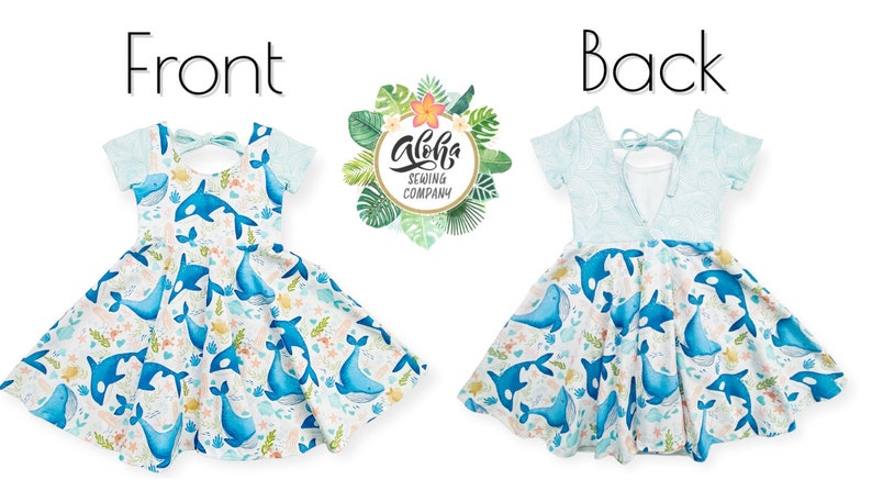 May include: A blue and white dress with a whale print. The dress has a tie at the back and short sleeves. The dress is made by Aloha Sewing Company.