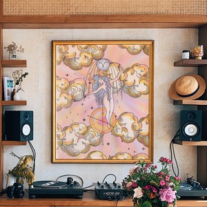Puede incluir: Una mesa de madera con un acabado de madera clara. La mesa est&aacute; en una habitaci&oacute;n con una estanter&iacute;a, un tocadiscos y una impresi&oacute;n enmarcada de una mujer de pie en las nubes. La impresi&oacute;n tiene un esquema de color rosa, amarillo y azul.