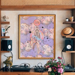 May include: A wooden table with a light brown finish sits in a room with a bookshelf, a record player, and a framed print of an astrological sign. The print is on a light purple background with a woman in a blue dress standing in front of a large circle with the symbol for Aquarius.