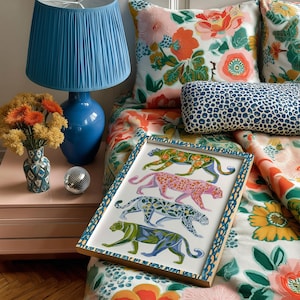 Four prowling leopards in vivid green, pink, sky-blue and indigo coats, each with whimsical floral patterns, stride across a cream backdrop. The bold dopamine palette enlivens living rooms, nurseries or eclectic gallery walls.