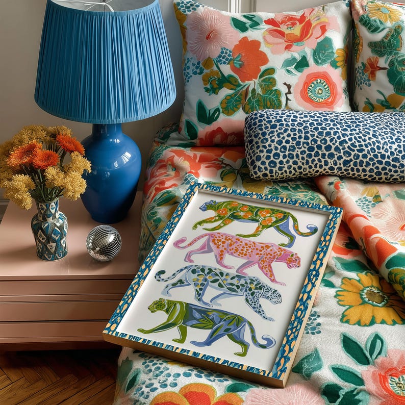 Four prowling leopards in vivid green, pink, sky-blue and indigo coats, each with whimsical floral patterns, stride across a cream backdrop. The bold dopamine palette enlivens living rooms, nurseries or eclectic gallery walls.