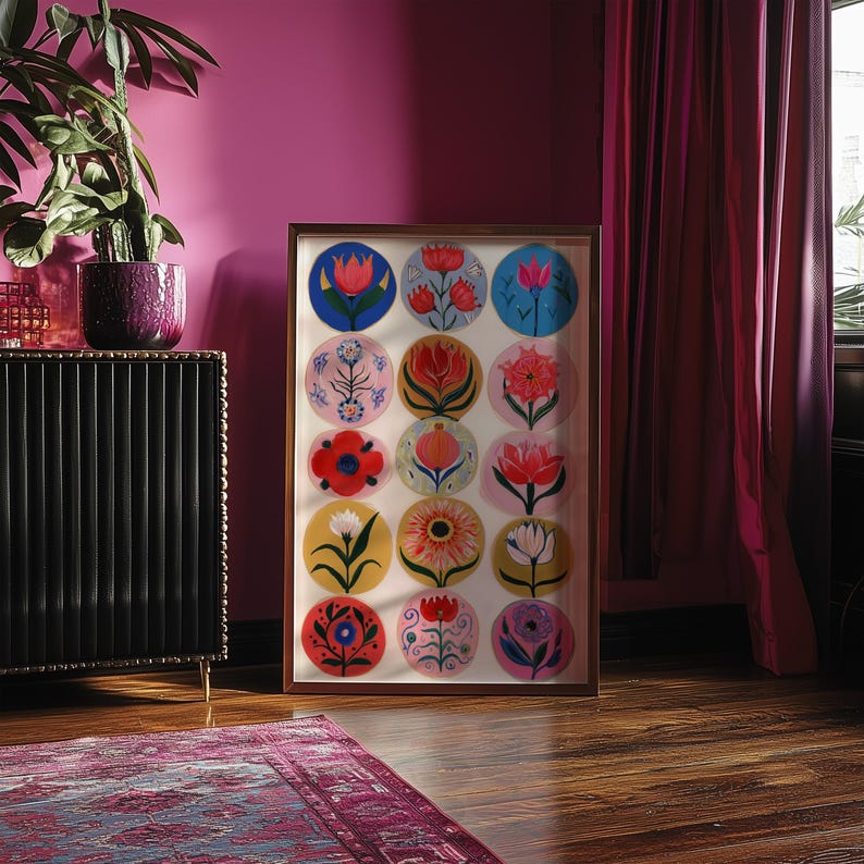 May include: Framed artwork featuring a collection of colorful floral designs in circular patterns. The artwork is displayed in a wooden frame, showcasing various flower illustrations in shades of red, blue, yellow, and pink. The artwork is set against a white background.