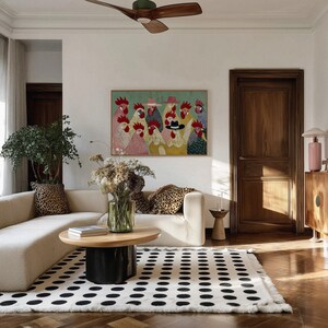 K&ouml;nnte beinhalten: Ein Wohnzimmer mit cremefarbenem Sofa, Kissen mit Leopardenmuster und einem schwarz-wei&szlig; gepunkteten Teppich. Vor dem Sofa steht ein Couchtisch aus Holz, und ein gerahmtes H&uuml;hnerkunstwerk h&auml;ngt an der Wand.