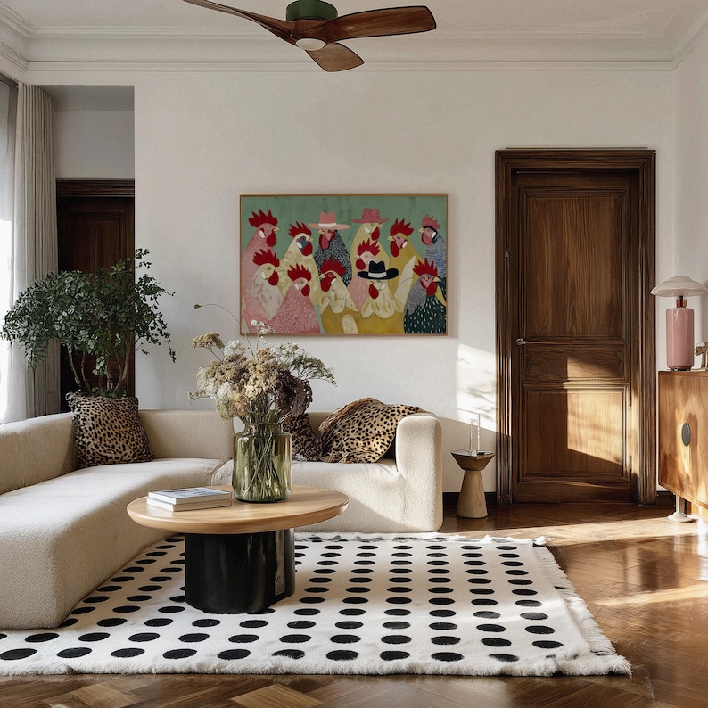 K&ouml;nnte beinhalten: Ein Wohnzimmer mit cremefarbenem Sofa, Kissen mit Leopardenmuster und einem schwarz-wei&szlig; gepunkteten Teppich. Vor dem Sofa steht ein Couchtisch aus Holz, und ein gerahmtes H&uuml;hnerkunstwerk h&auml;ngt an der Wand.