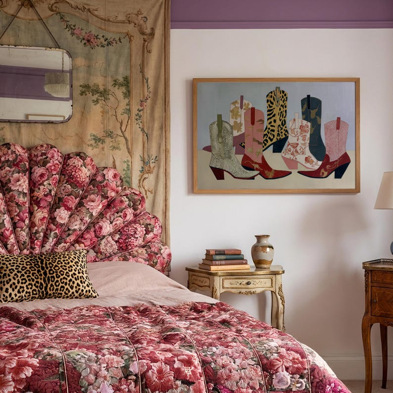 May include: A bedroom scene featuring a floral patterned headboard and bedding. A framed artwork of colorful cowboy boots hangs on the wall. A leopard print pillow rests on the bed, and a small side table holds books and a vase.