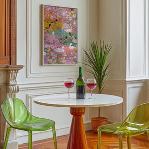 May include: A dining scene with a round white table on an orange base, two clear green chairs, and a framed painting of ducks in a floral setting. A green wine bottle and two glasses of red wine are on the table.