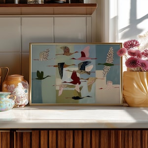 May include: A rectangular framed print featuring a flock of stylized birds in flight against a background of vertical color blocks in shades of blue, green, and cream. The birds are depicted in various colors and patterns, including spotted, solid, and textured designs.