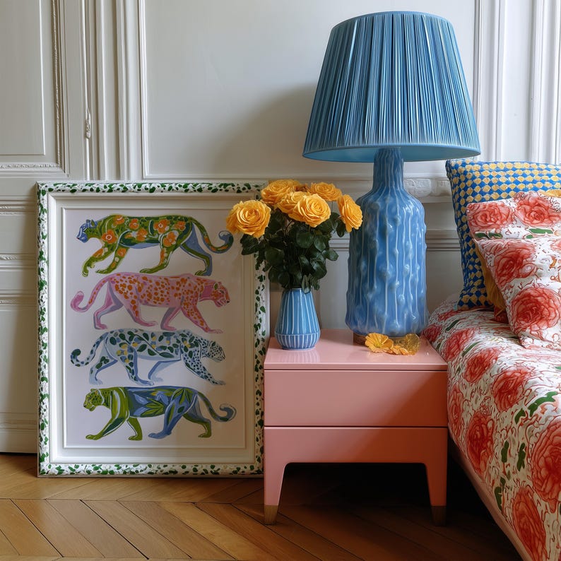 Four prowling leopards in vivid green, pink, sky-blue and indigo coats, each with whimsical floral patterns, stride across a cream backdrop. The bold dopamine palette enlivens living rooms, nurseries or eclectic gallery walls.