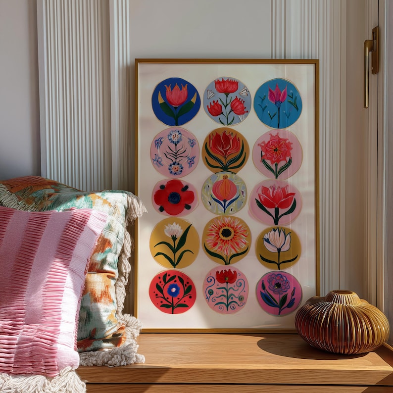 May include: A framed art print featuring colorful floral designs in circular patterns. The artwork showcases various flowers in shades of red, pink, blue, and yellow, set against different colored backgrounds. The frame is gold.
